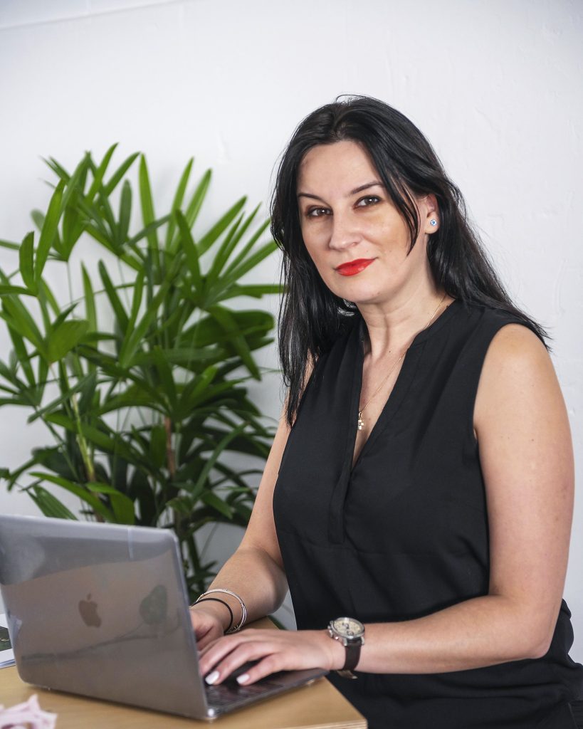 Alexandra Morosan, founder of Event Management by Alex, working at a laptop